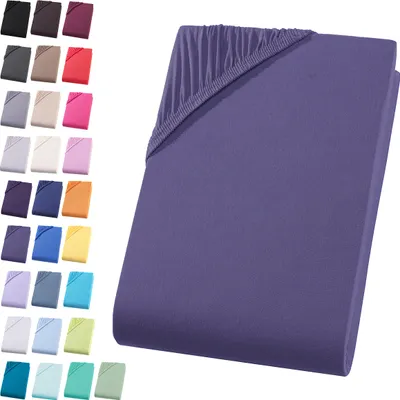A folded purple fitted sheet is shown on a white background, with a swatch of other colored fitted sheets visible on the left side of the image.