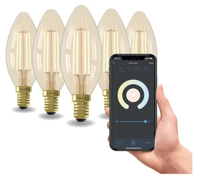 A hand holding a smartphone displaying a smart bulb app, with a set of smart LED filament bulbs in the background.