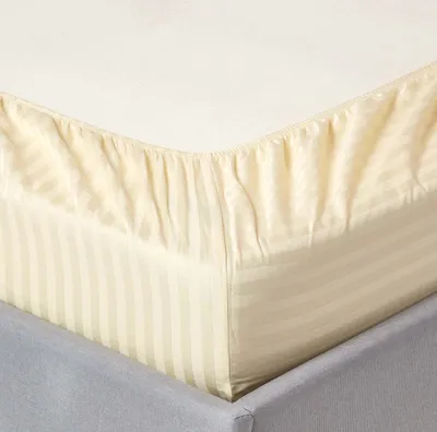 A close-up view of a fitted sheet on a bed.
