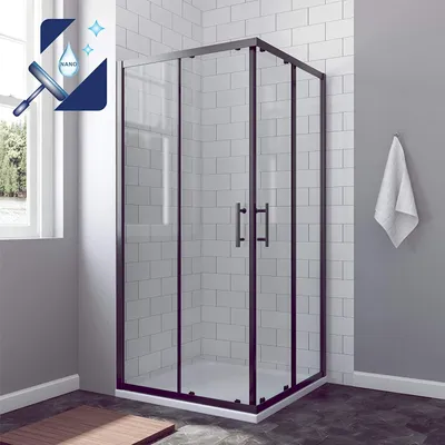 A modern black framed shower enclosure with sliding doors, set in a bathroom with white tiled walls and a grey wall with a towel hanging on it.