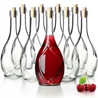 A group of clear glass bottles with cork stoppers, one of which is filled with red liquid. Three cherries are in the foreground.