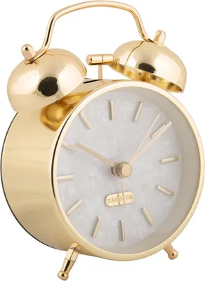 A close-up, studio shot of a gold alarm clock with a pearl-like white face.