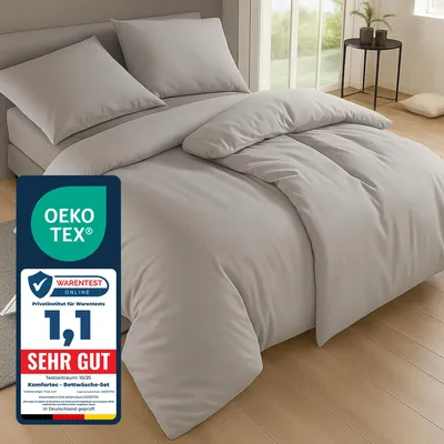 A neatly made bed with gray bedding, featuring a prominent certification label in the foreground.