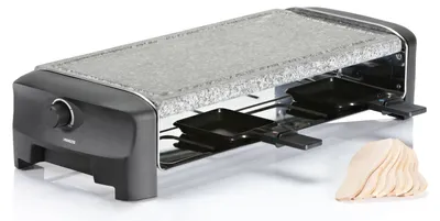 A raclette grill with a stone top and eight small pans underneath, along with a stack of wooden spatulas.