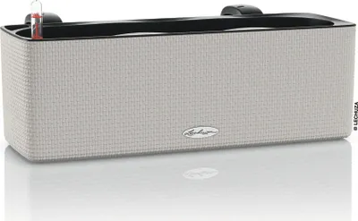 A rectangular planter box with a textured exterior and a black inner rim, shown on a reflective white surface.