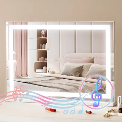 A vanity mirror with LED lighting is placed on a dresser in a bedroom setting.