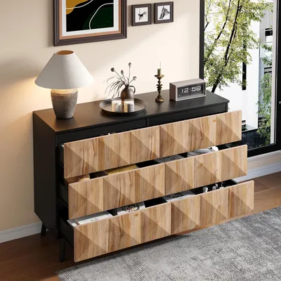 A dresser with open drawers in a room with a window.