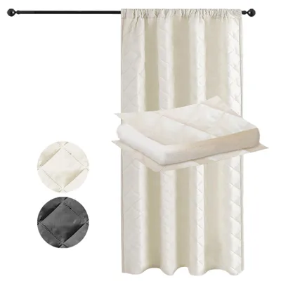 A beige quilted curtain hanging on a black curtain rod, with a folded beige quilted blanket or fabric sample placed on top of it.