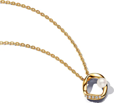 A close-up studio shot of a gold necklace with a pendant.