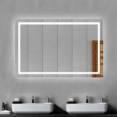 A modern bathroom with two sinks and a large LED mirror.