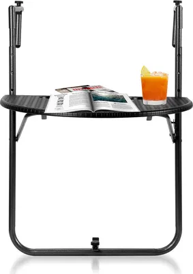 A black balcony hanging table with a magazine and a drink on it.