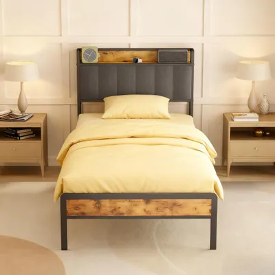 A single bed with yellow bedding is shown in a bedroom setting with nightstands and lamps on either side.