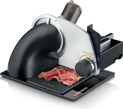 A Graef SKS 72011 Allesschneider with sliced ham on its cutting surface, presented on a black base against a white background.