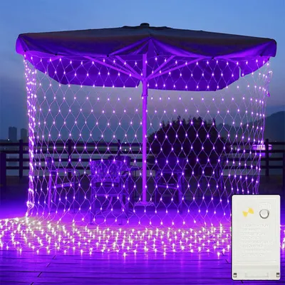 A patio umbrella decorated with purple net lights at dusk.