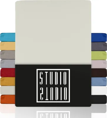 A stack of fabric swatches in various colors, with a large beige swatch in the foreground and a black panel with white text below it.