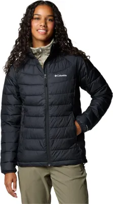 A woman wearing a black puffer jacket and tan pants.