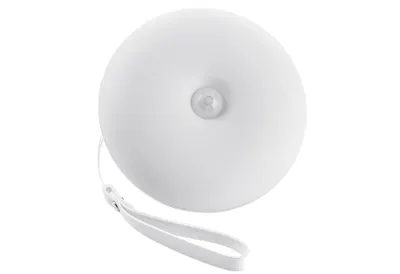A white, round night light with a motion sensor in the center and a white strap attached to the side, isolated on a white background.