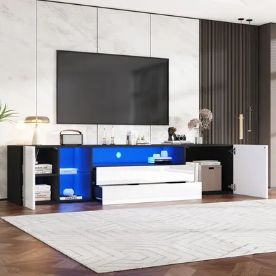 A modern, black and white TV stand with blue LED lighting, featuring drawers and cabinets, set in a living room environment.