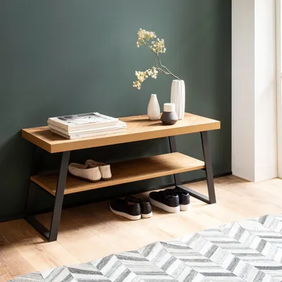 A shoe bench with shoes and books in a hallway.