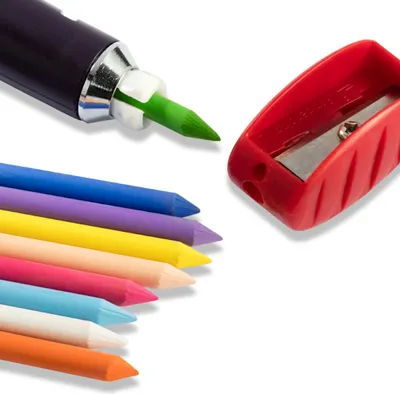 A close-up shot of art supplies, including a marker with a green tip, a red pencil sharpener, and a collection of colorful crayons.