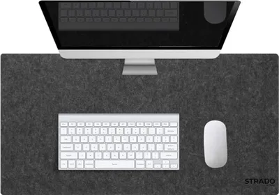 A desk setup with a computer monitor, keyboard, and mouse on a gray desk mat.