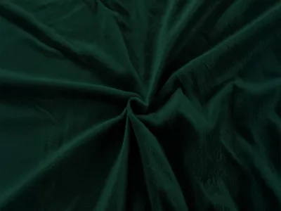 A close-up, top-down view of a crumpled dark green microfiber fabric, likely a bedsheet, with soft folds and shadows.