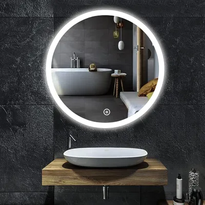 A modern bathroom with a round LED mirror above a wooden vanity and sink.