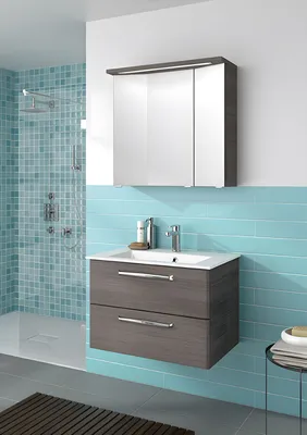 A modern bathroom vanity with a sink, mirror cabinet, and shower.