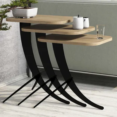 A set of three nesting side tables with wooden tops and black curved metal legs, placed against a wall.