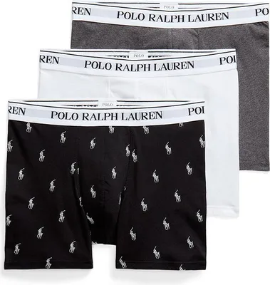 Three pairs of men's boxer shorts are stacked on a white background. The top pair is gray, the middle pair is white, and the bottom pair is black with a repeating pattern of white polo player logos.