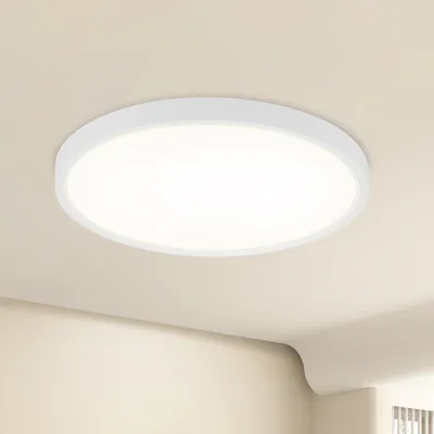 A white, circular LED ceiling light is mounted on a light beige ceiling.