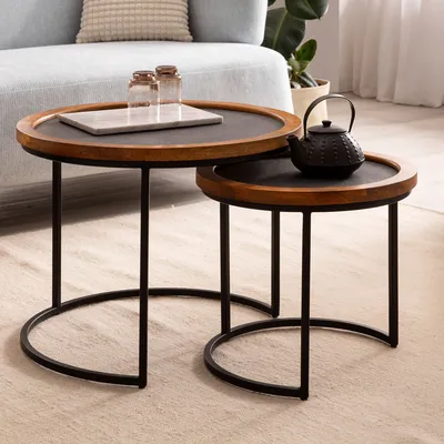 Two nesting coffee tables are shown in a living room setting, next to a sofa.