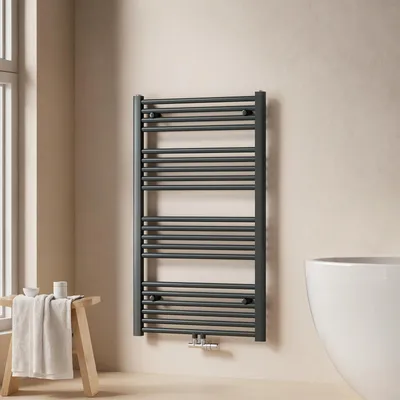 A modern bathroom setting with a towel warmer, a stool with a towel, and a bathtub.
