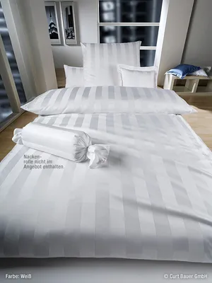 A neatly made bed with white striped bedding, including a duvet, pillows, and a bolster pillow.