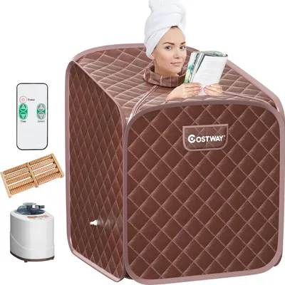 A woman is inside a portable sauna, reading a book. Accessories for the sauna are laid out around it.