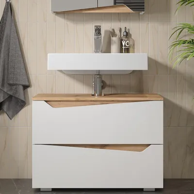 A modern bathroom vanity with a sink and two drawers, set against a tiled wall.