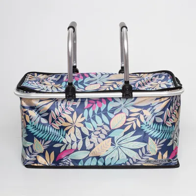 A picnic basket with a floral leaf pattern and silver handles against a white background.