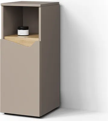 A modern, tall, narrow cabinet with a door and an open shelf, placed against a white wall with a shadow.