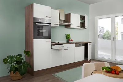 A modern kitchen with white cabinets, wood accents, and stainless steel appliances.