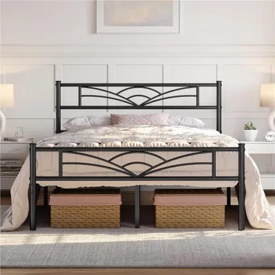 A black metal bed frame with a decorative headboard and footboard, set up in a bedroom with bedding.