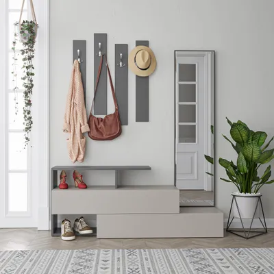 An entryway with a coat rack, shoe bench, mirror, and plant.