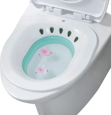 A close-up view of a white bidet attachment with water and pink flower petals inside.