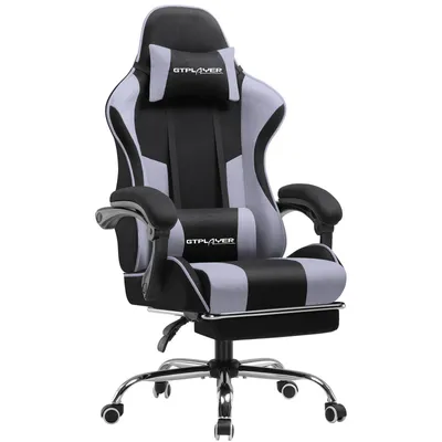 A gaming chair with a footrest, headrest, and lumbar cushion.