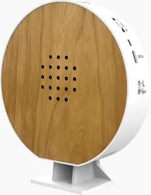 A round device with a wood-grain front and white sides, mounted on a white stand.