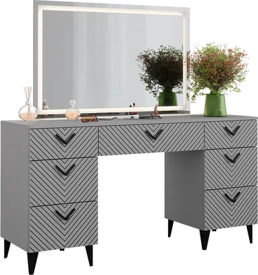 A vanity table with a large LED mirror and decorative items.