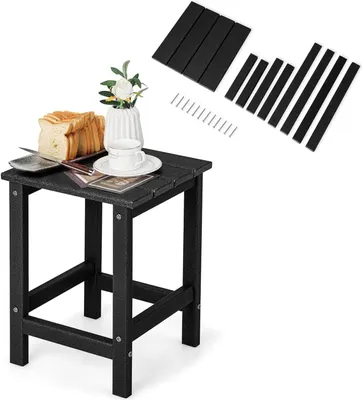 A small black side table with a slice of bread, a cup of tea, and a vase of flowers on top. The table is shown assembled, and next to it are unassembled parts and screws.