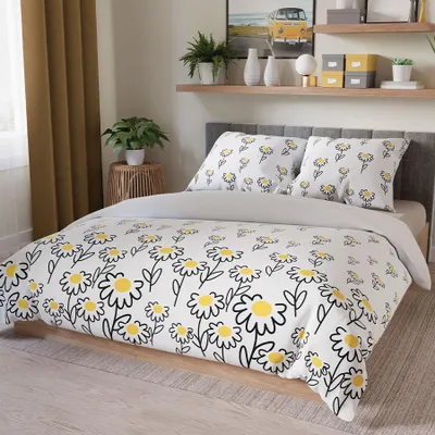 A bedroom scene with a bed dressed in daisy-patterned bedding.