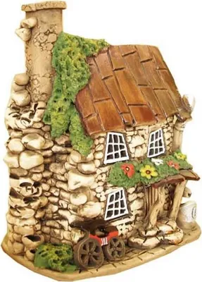 Keramikhaus das ein mit Steinen gebaute Herberge darstellt. Haus hat braunes schindelartiges Dach.