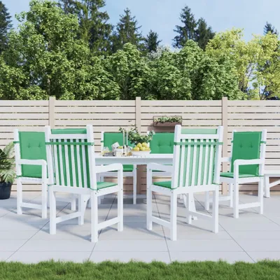 An outdoor patio set with chairs and a table, set against a backdrop of trees and a wooden fence.