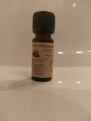Kleine braune Flasche mit einem schwarzen Verschluss. Auf dem Etikett steht "Adventsmischung".